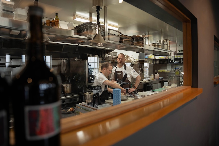 Two men stand in a restaurant kitchen