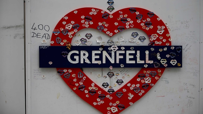 A tribute in the shape of a love heart and with the word 'Grenfell' hands on a wall.