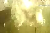 Blurry security cam screenshot of a large burst of flames.