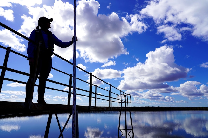 Photo of a woman standing near water.