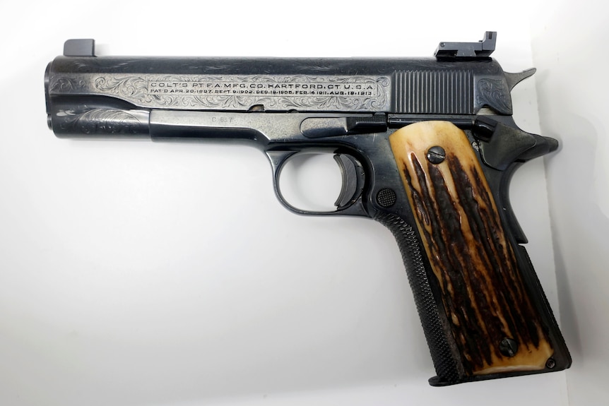 A 1911 Colt .45 pistol belonging to Al Capone sits on a white background before auction.