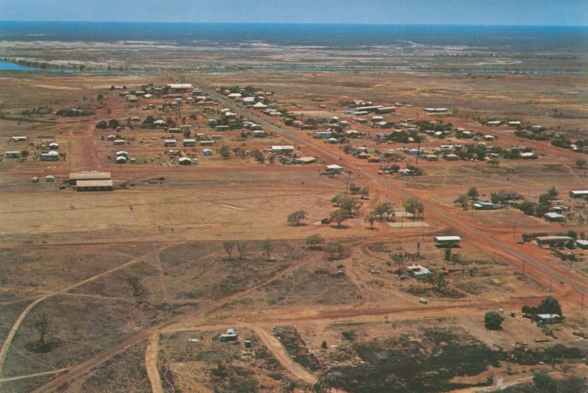 An aerial view of an outback town surrounded with nothing but red dirt plains