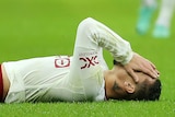 Antony of Manchester United lies on the ground with his hands on his face after a Champions League game.