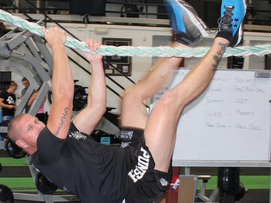 Fit looking man on a rope climb