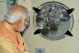 A photo of Narendra Modi peering out of a window, which has been photoshopped to show buildings in Tamil Nadu.