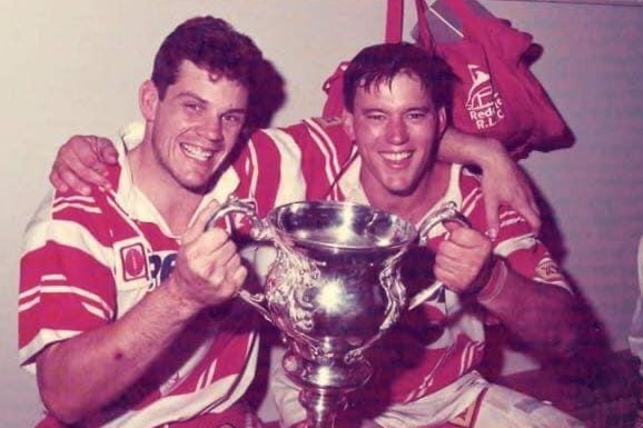Ian Graham in the red and white jersey in the dressing room after a grand final win.