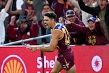 Brisbane Lions forward Charlie Cameron sprints away from goal, with his finger pointed in celebration as the crowd cheers. 