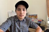 Young man in button-up shirt and cap