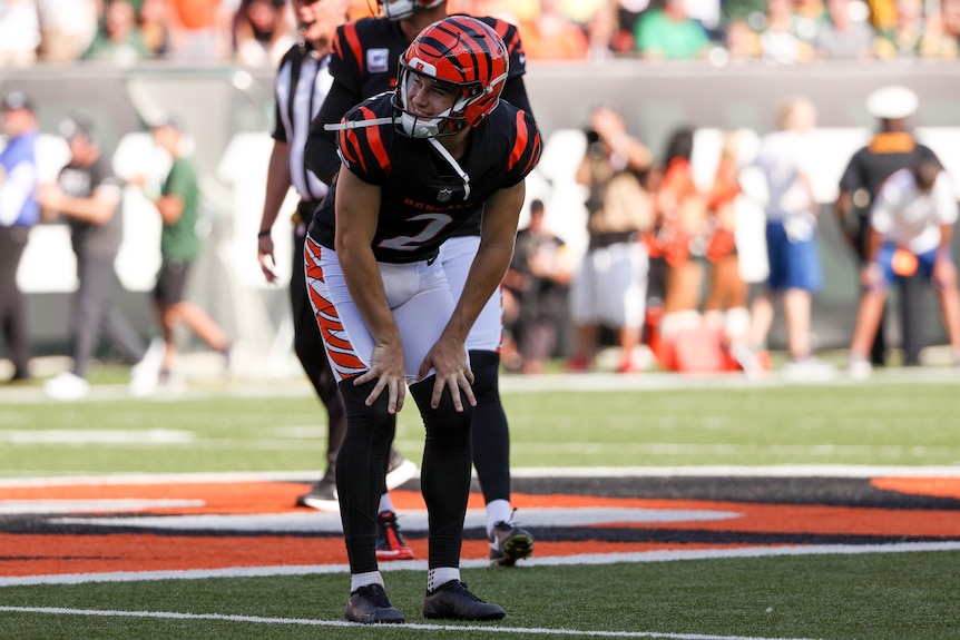 Evan McPherson leans forward with his hands on his knees, looking to his right