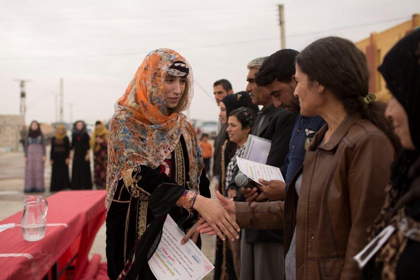 A female student with a graduation certificate shakes hands with workshop leader
