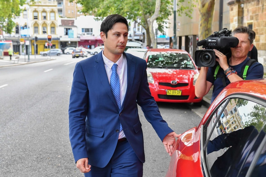 A man in a suit walks on the road