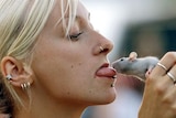 A girl kisses her pet rat