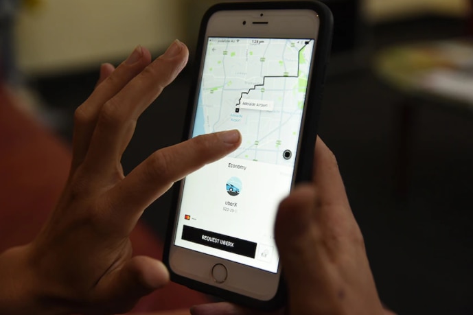 Person holding a phone tracking an Uber driver