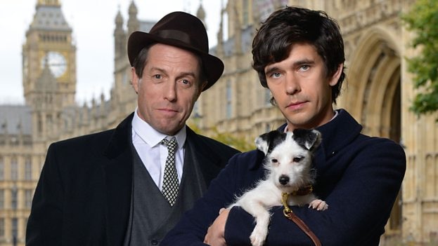 Hugh Grant stands beside Ben Whishaw, who holds a dog, in front of Parliament house in London