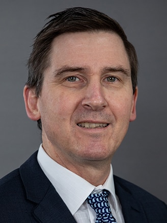 Queensland's chief psychiatrist Dr John Reilly wears a suit jacket and tie