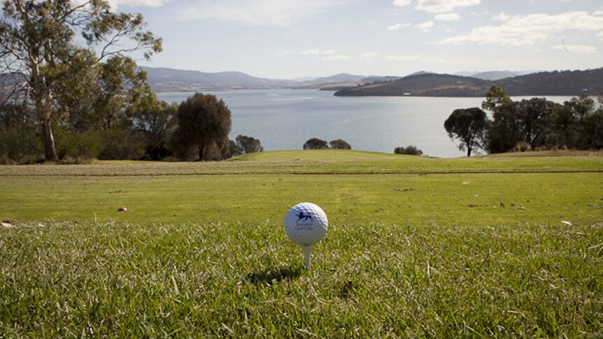 A golf ball in the forefront of the view from Tasmania Golf Club.