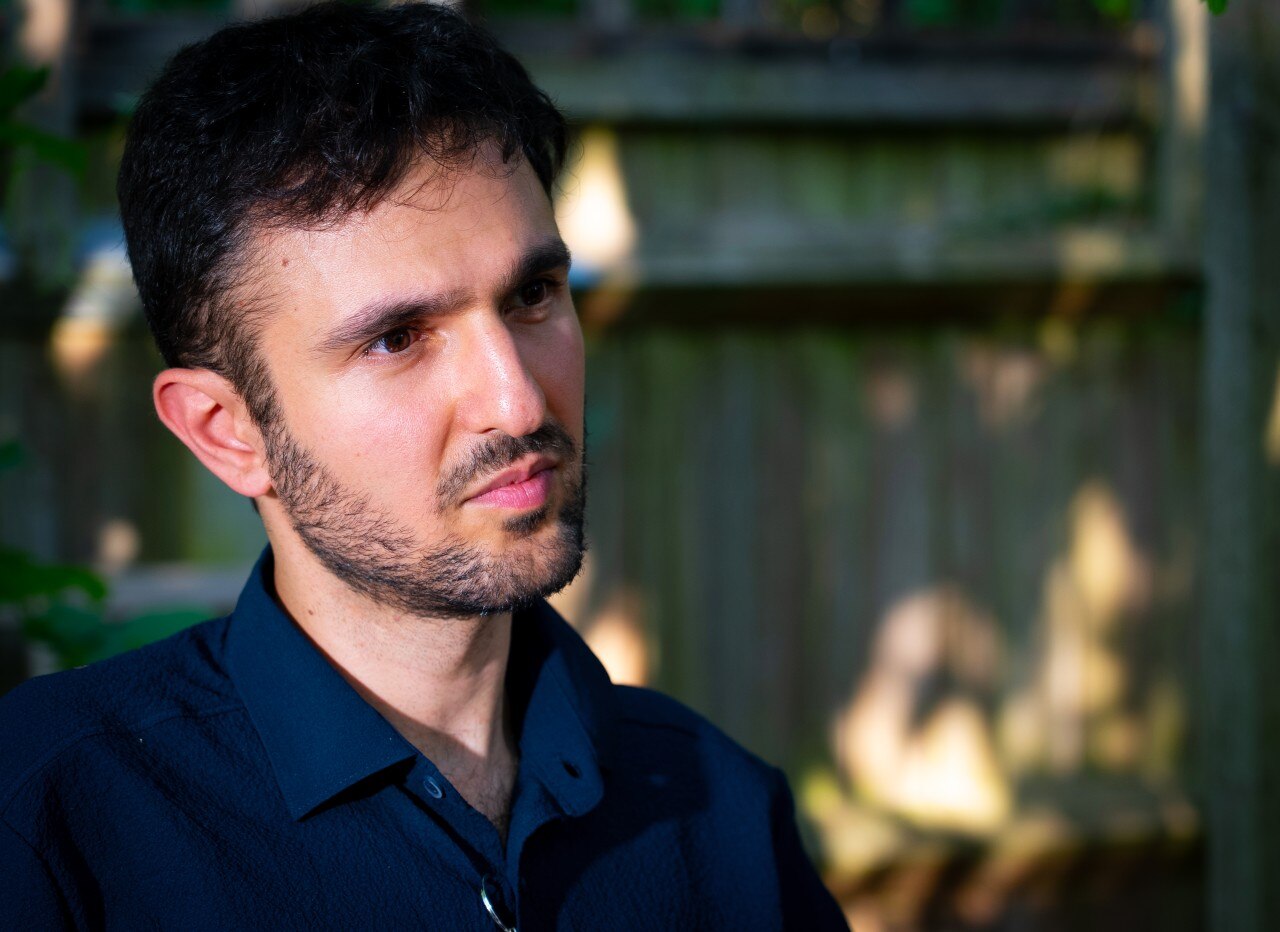 A man looking on with a neutral expression.