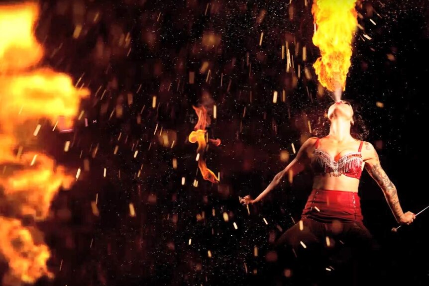 A dancer blasts flames out of her mouth