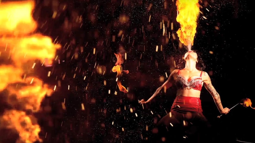 A dancer blasts flames out of her mouth