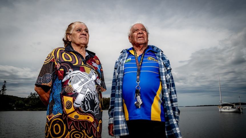 Karuah elders Hector and Venessa Saunders stand on a jetty