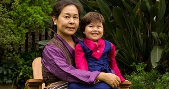 Lhakyi sits on her mother, Kyinzom's knee.