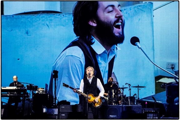 Paul McCarthy live in Glastonbury, with John Lennon behind him.