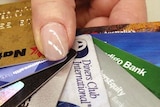 A hand holds numerous credit cards