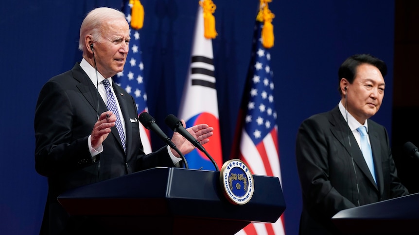 Joe Biden and Yoon Suk Yeol stand behind lecterns flanked by South Korean and American flags.