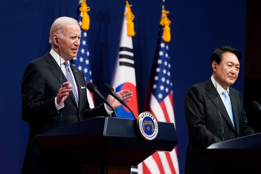 Joe Biden and Yoon Suk Yeol stand behind lecterns flanked by South Korean and American flags.