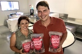 Allison and Stuart McGruddy holding up packets of their frozen strawberries.