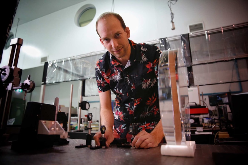 Francis Bennet bends over a lab table.