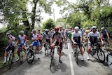 Cyclists in the Tour de France pausing on the road during a stage.