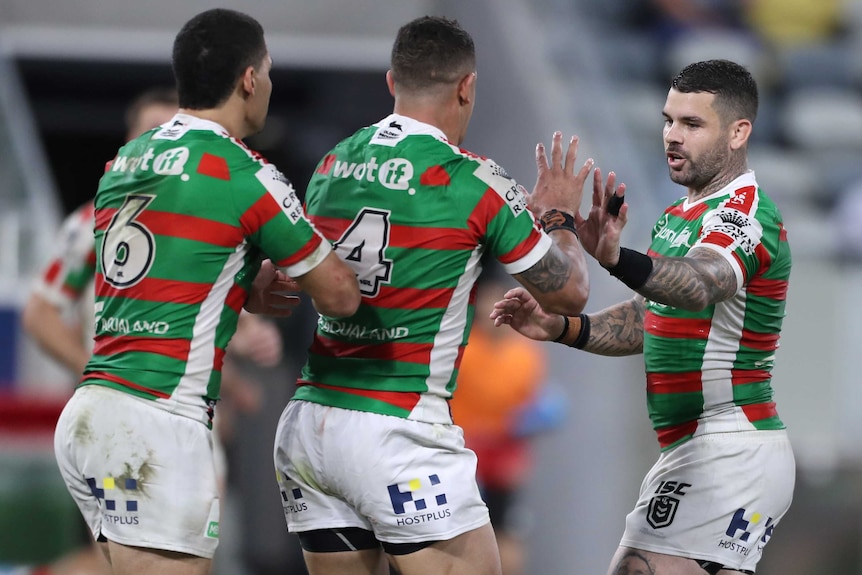 Two South Sydney NRL players congratulate a teammate after kicked the winning field goal against North Queensland.