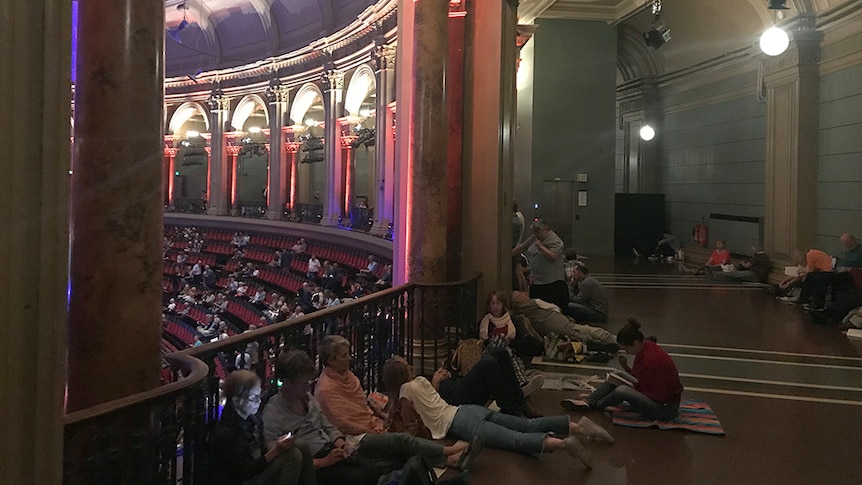 inside of the Royal Albert Hall in London, showing arches and the sweeping curve of the upper gallery.