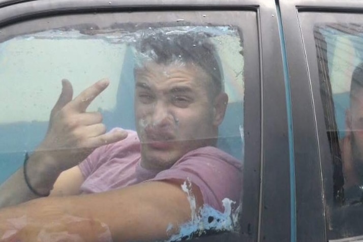 A man in the front seat of a car filled with water.