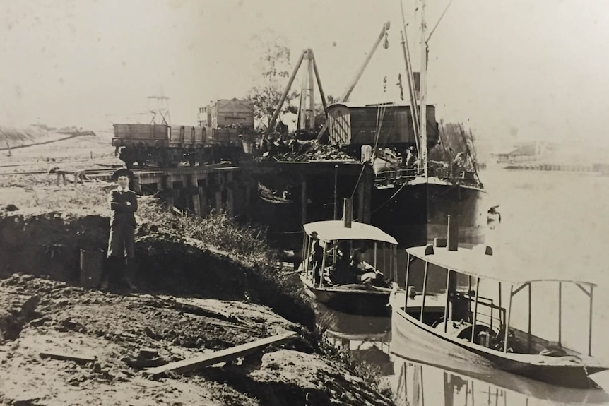 Black and white photo og ships with child in foreground