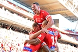 Three NRL players celebrate a try