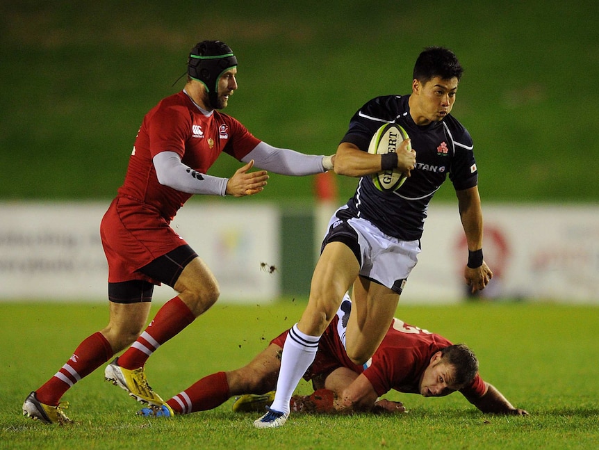 Akihito Yamada of Japan evades the tackle of Alexey Makovetskiy of Russia during the International Match between Japan and Russia