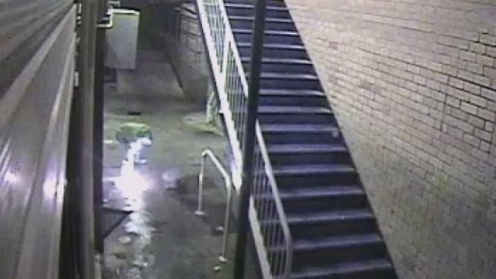 CCTV footage showing a man lighting a trail of accelerant outside the cafe's back entrance.