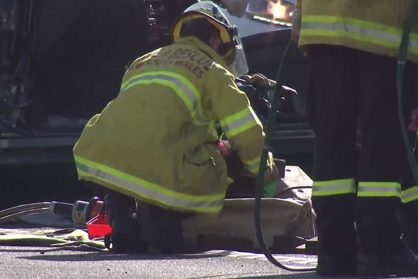 An emergency worker crouches down at the scene