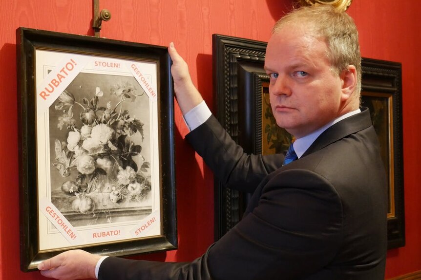Director of the Uffizi Gallery Eike Schmidt stands with a copy of the painting 'Vase of Flowers'