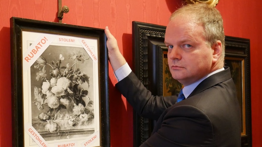 Director of the Uffizi Gallery Eike Schmidt stands with a copy of the painting Vase of Flowers