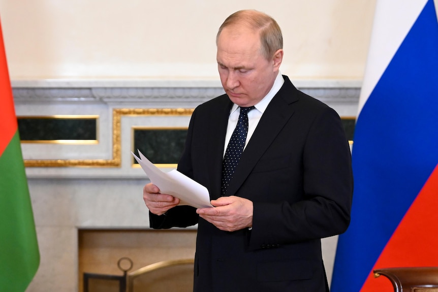 Le président russe Vladimir Poutine lit un document