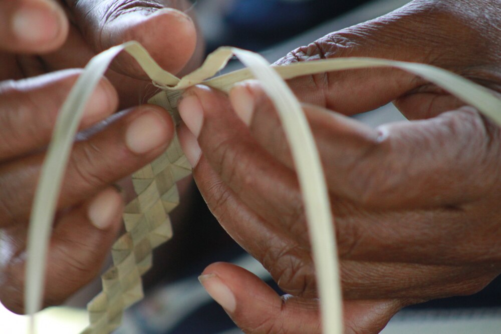 Close -up of the hands of the woman weaving a sennit.