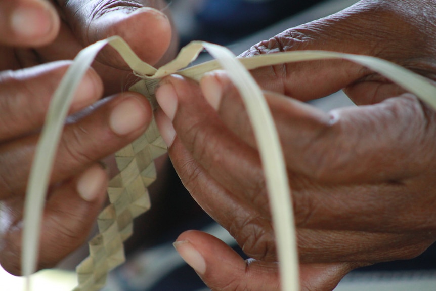 Close-up of woman's hands weaving a sennit.