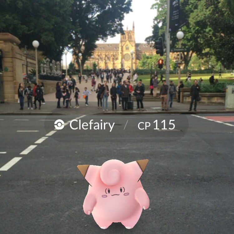 A pink Pokemon character on Elizabeth Street with Hyde Park in the background.