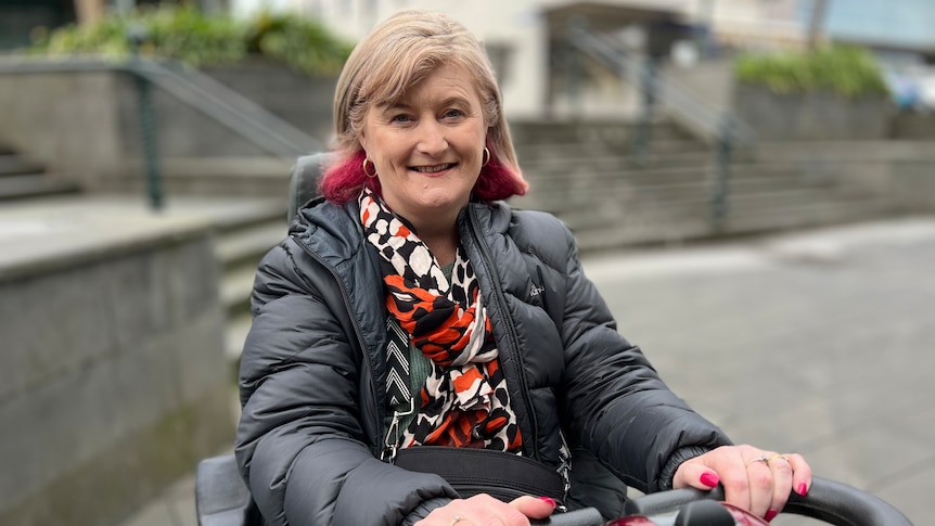 A woman with a black jacket and bright scarf.