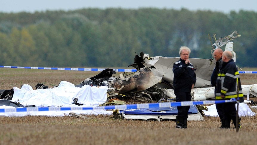 Belgian firefighters inspect pieces of debris at the site where the plane crashed.