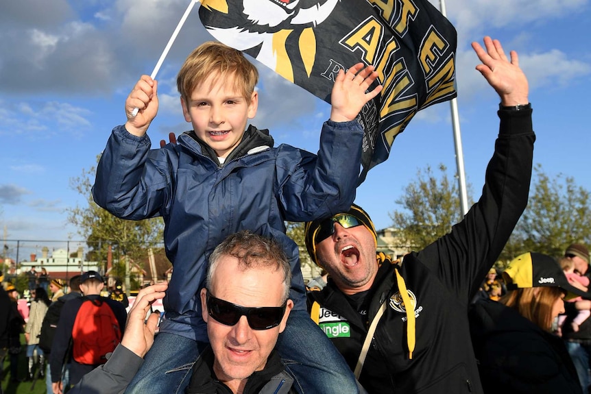A young fan sits on his dad's shoulders