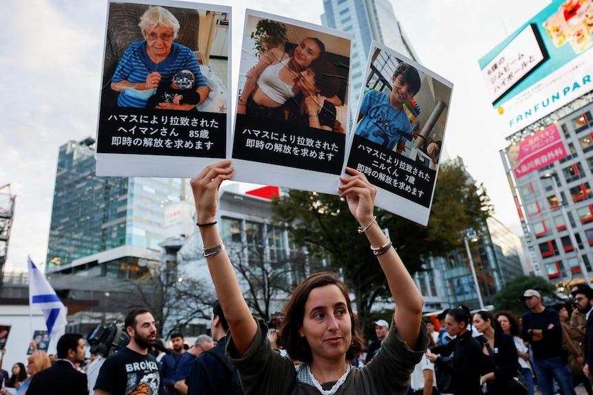 A female protester holding up three images. 